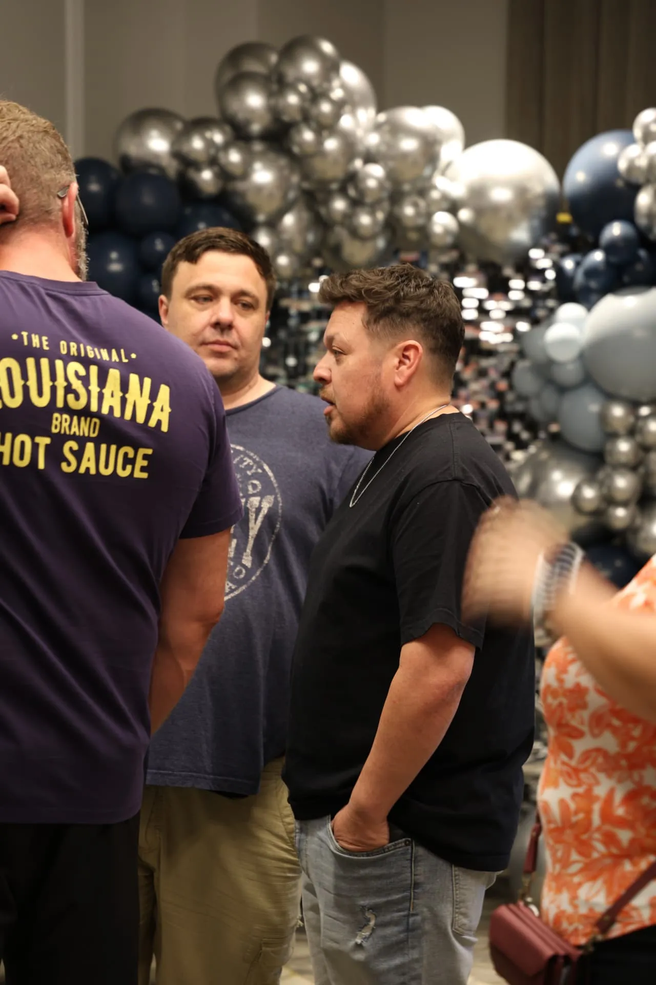 Agents talking in front of a navy and silver balloon display